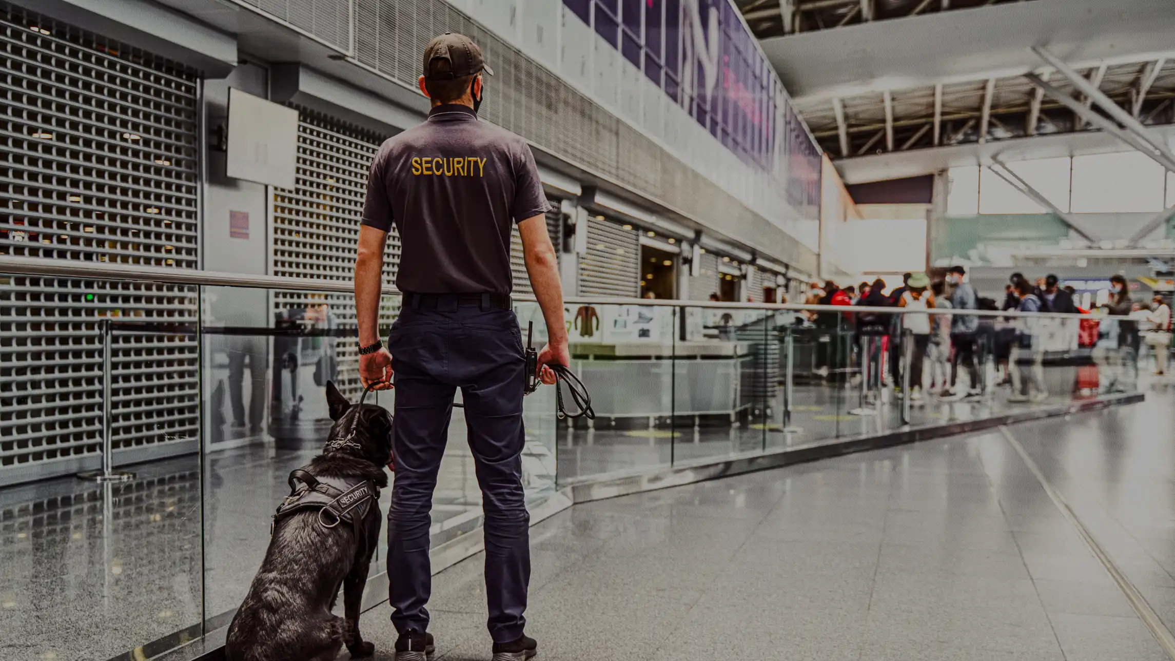 Security officer standing with deputy dog in airport terminal