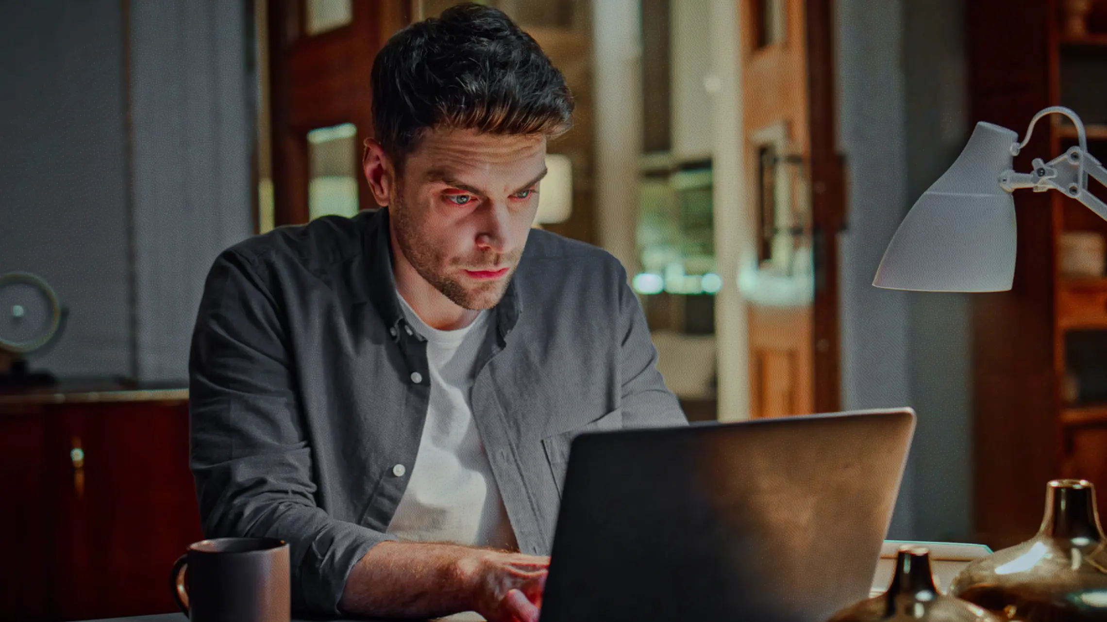 Man sitting at desk typing on laptop