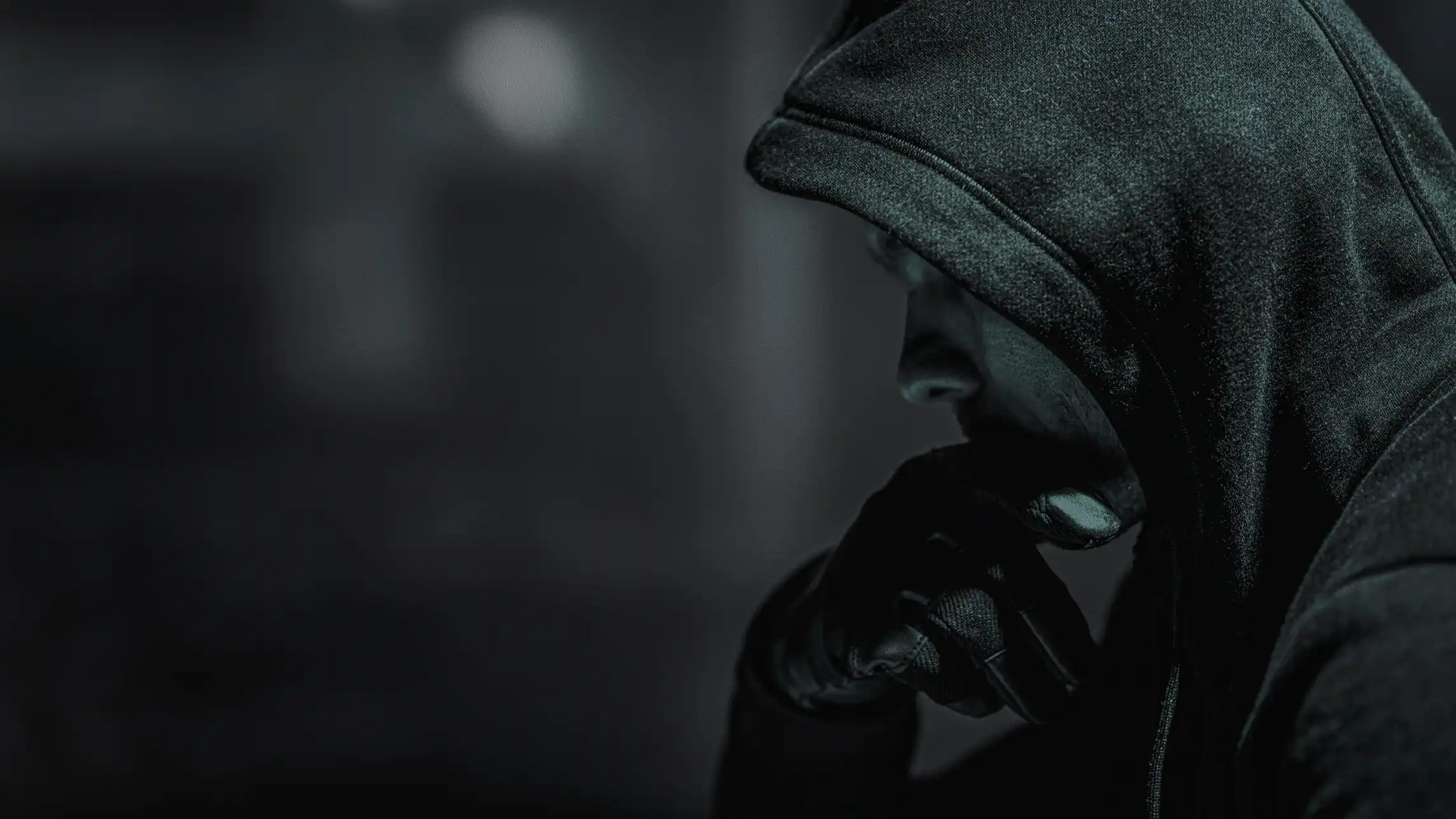 Hooded figure conducting nefarious activity in the dark