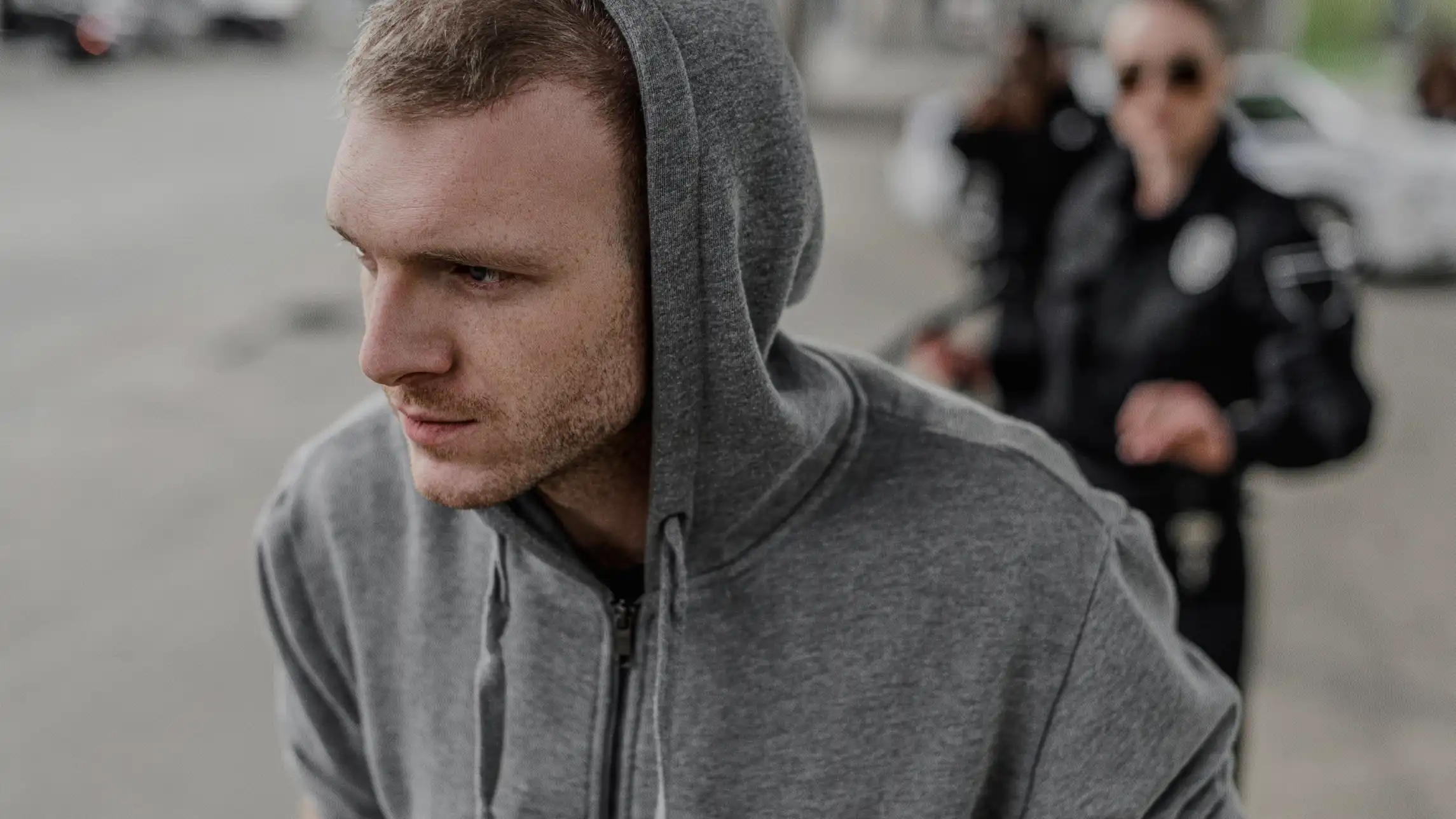 Hooded man being apprehended by police on street