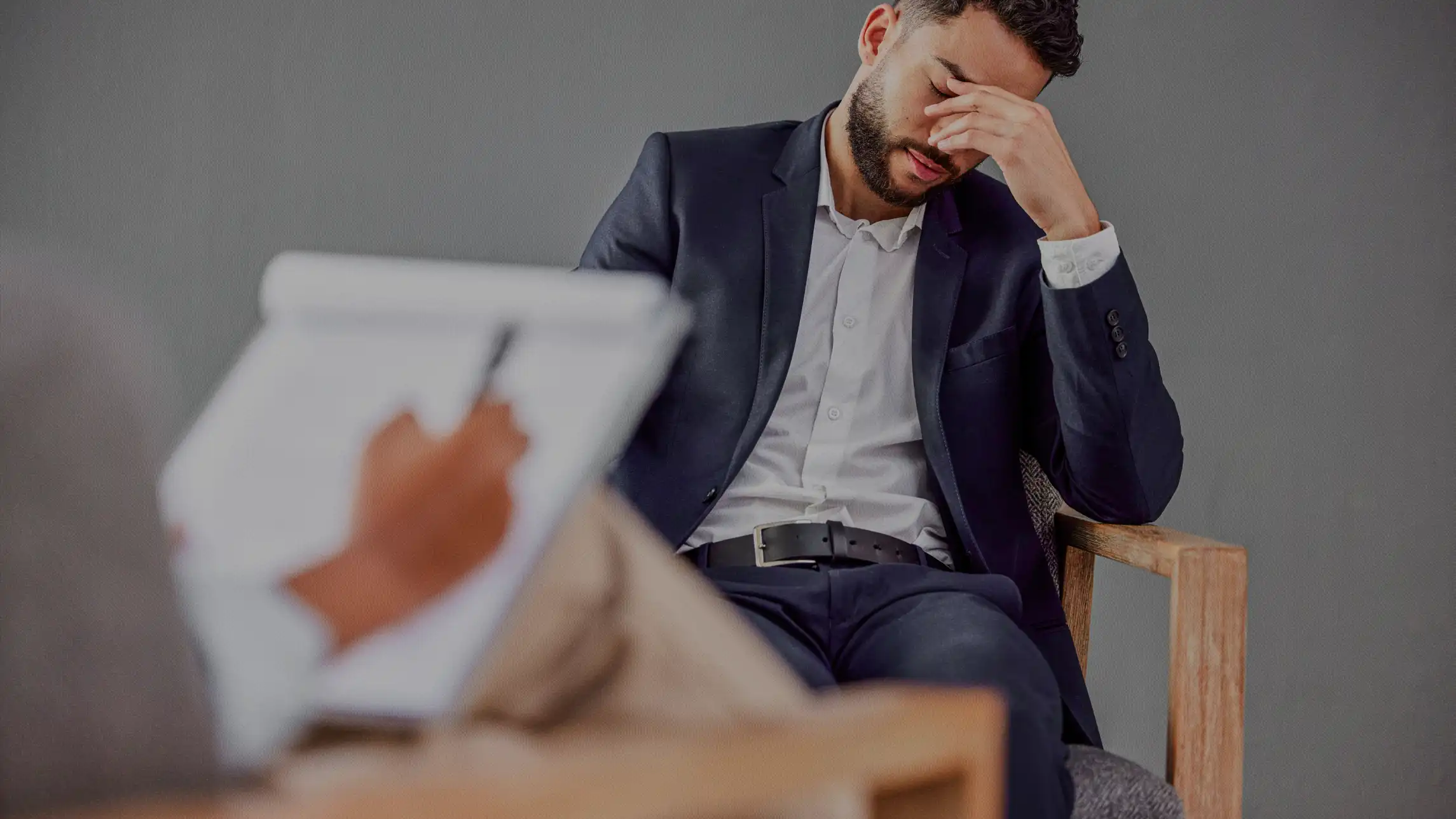 Upset man in business suit discussing case with counselor