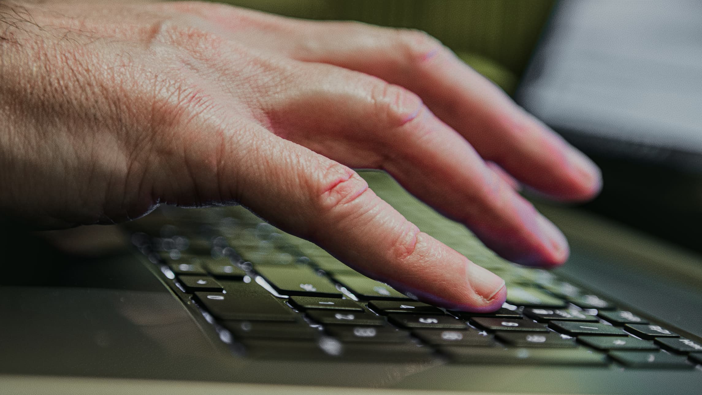 Man's hand typing on laptop