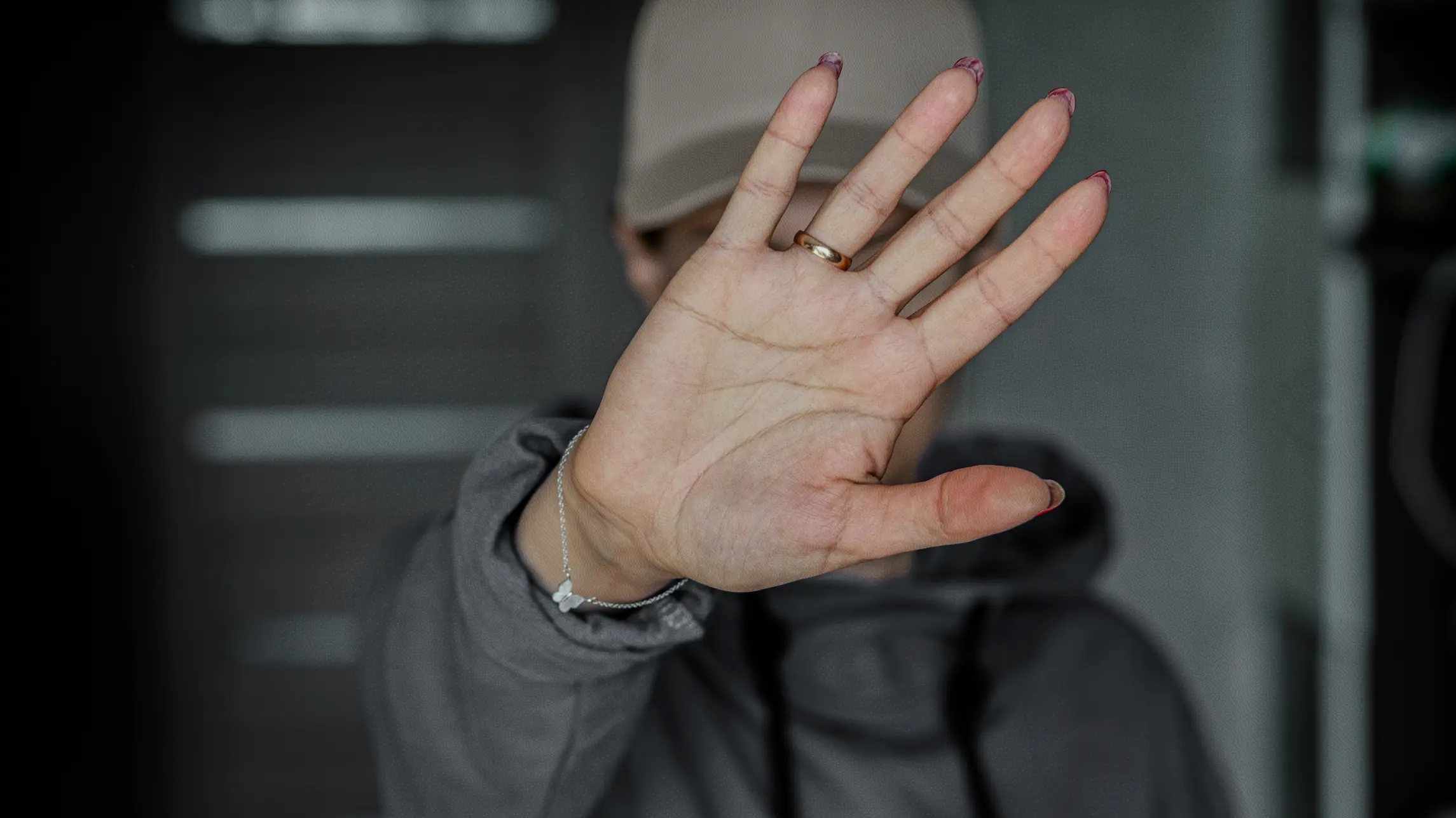 Woman shielding her face from the camera with her hand