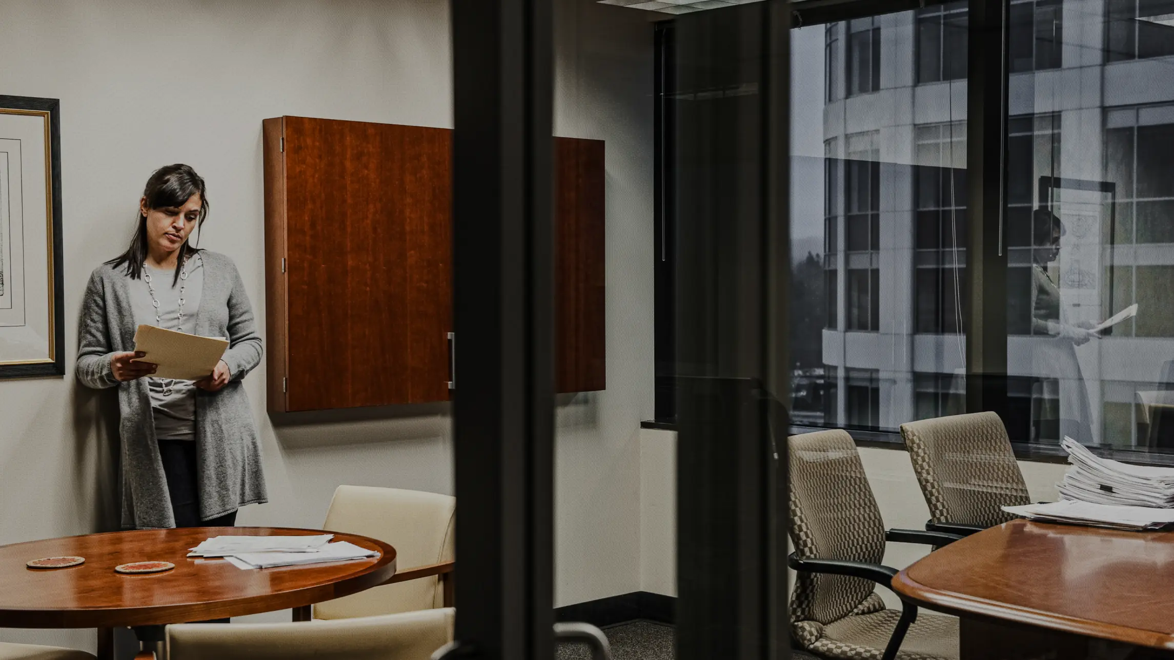 Woman looking over paperwork in dark office setting