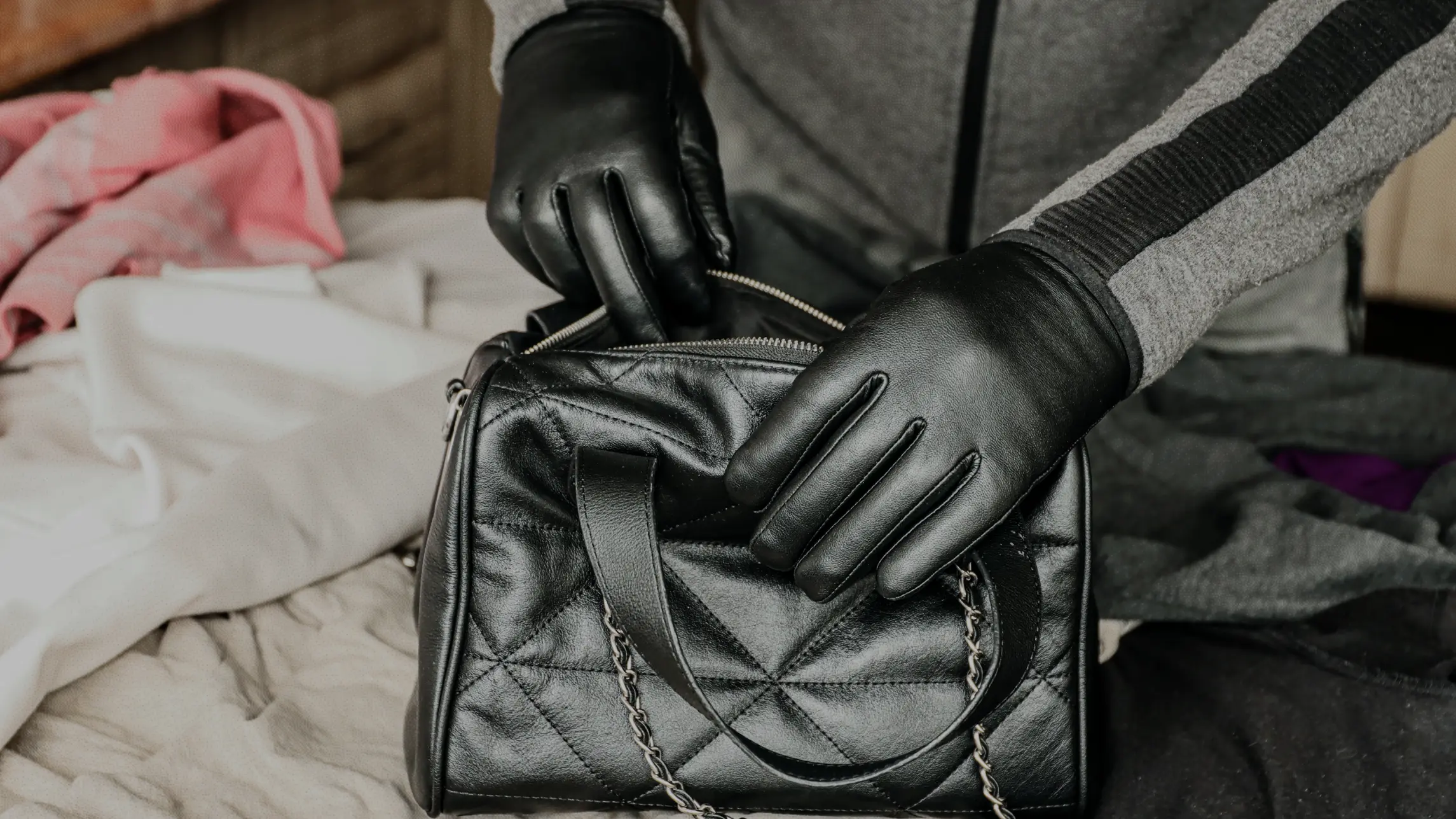 Person with gloves on rustling through leather purse in another person's bedroom