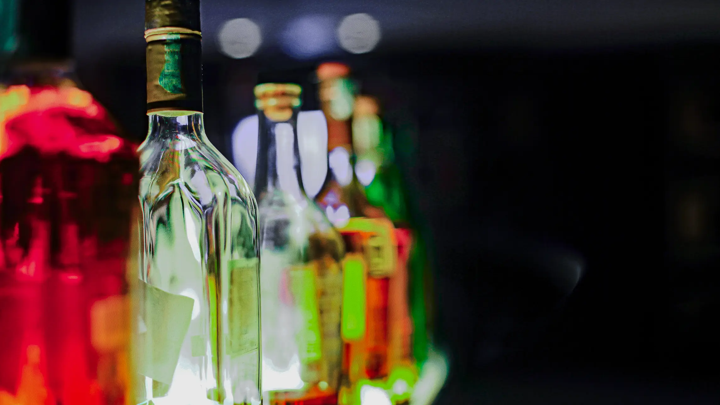 Liquor bottles glowing in bar light