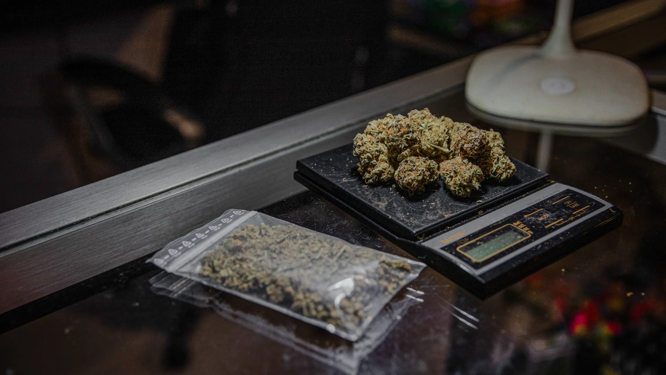 Marijuana being weighed on scale and in baggy on table