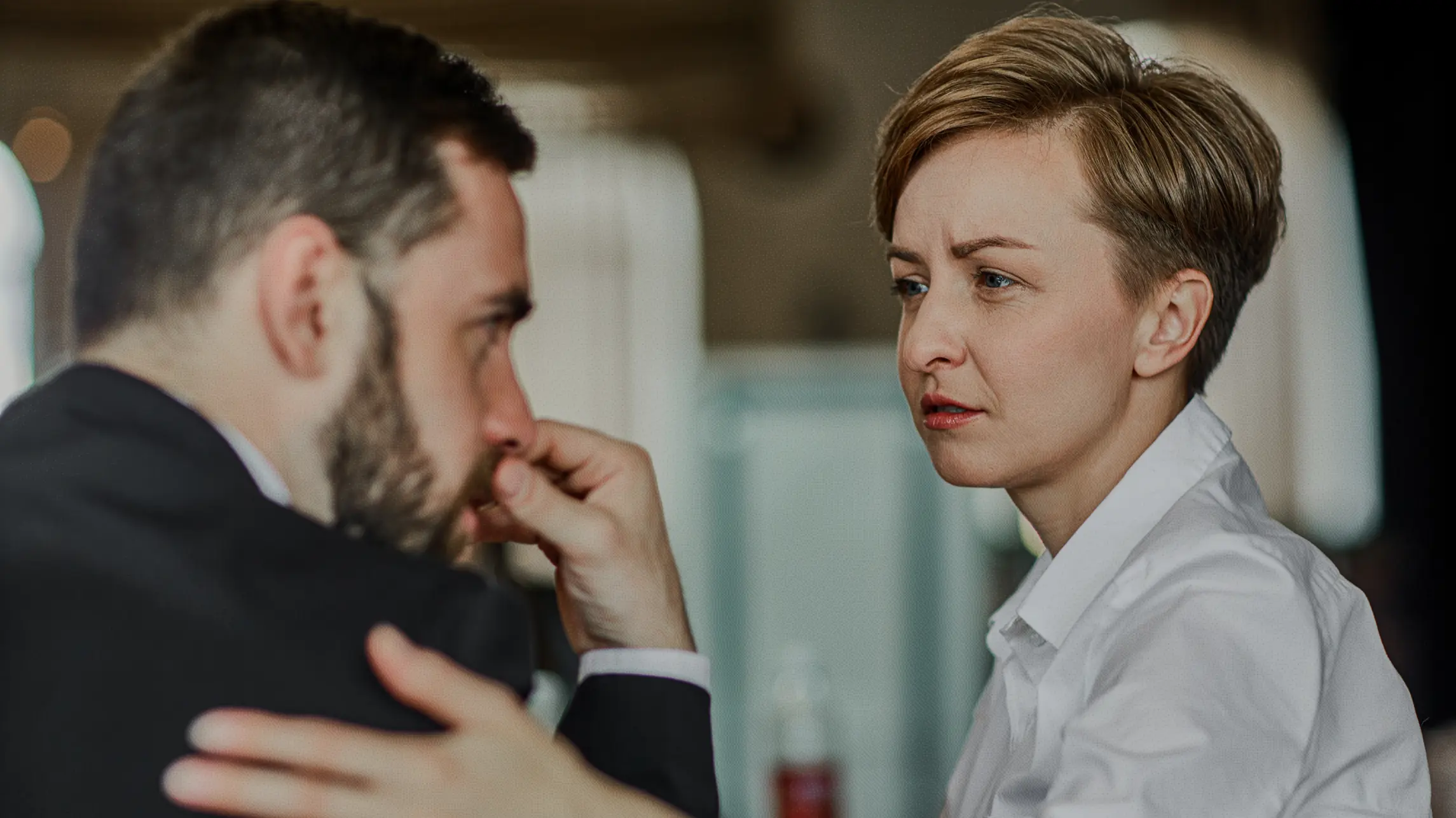 Woman in business clothes comforting nervous man in suit