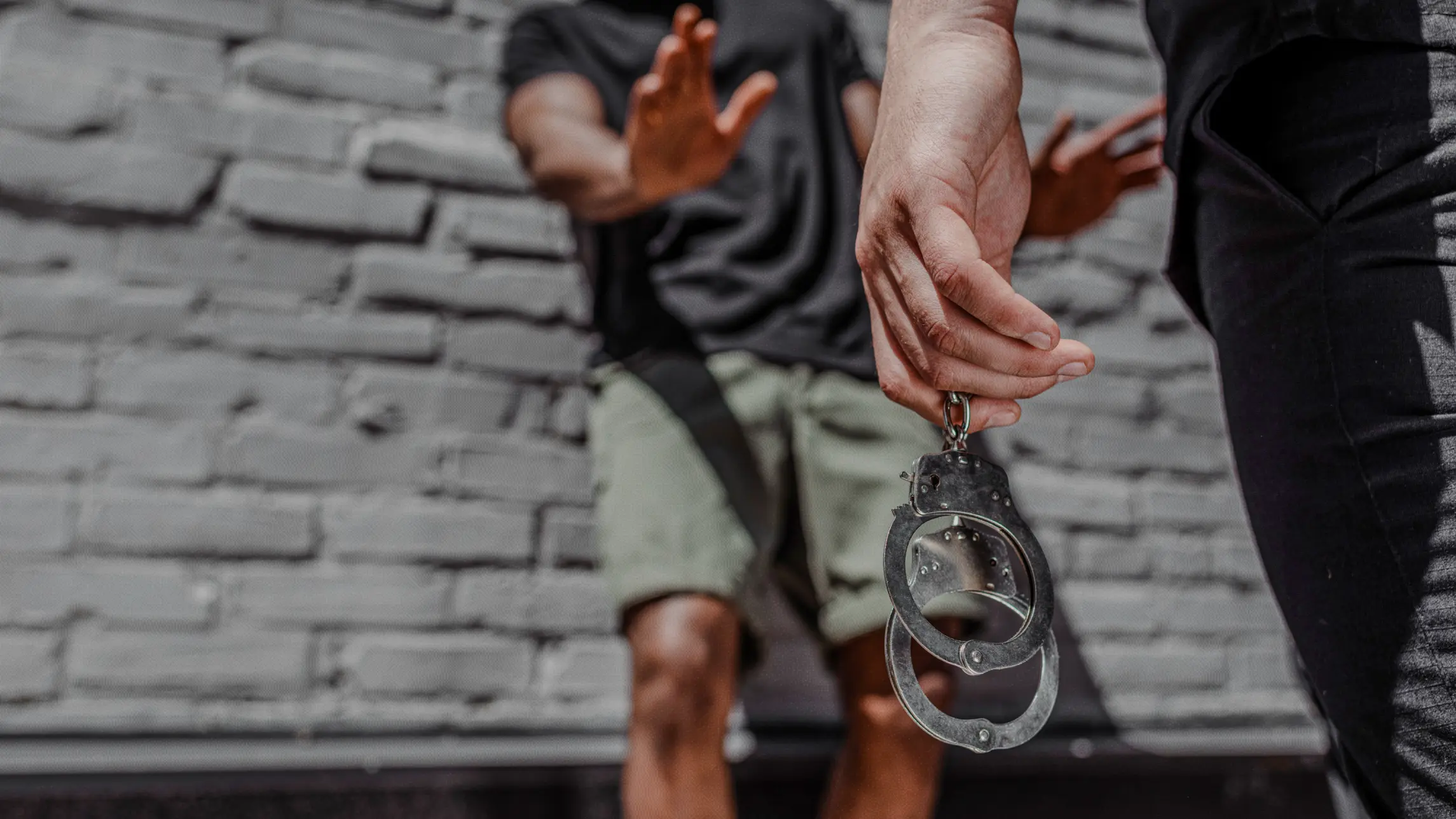 Person trying to handcuff a man who is resisting