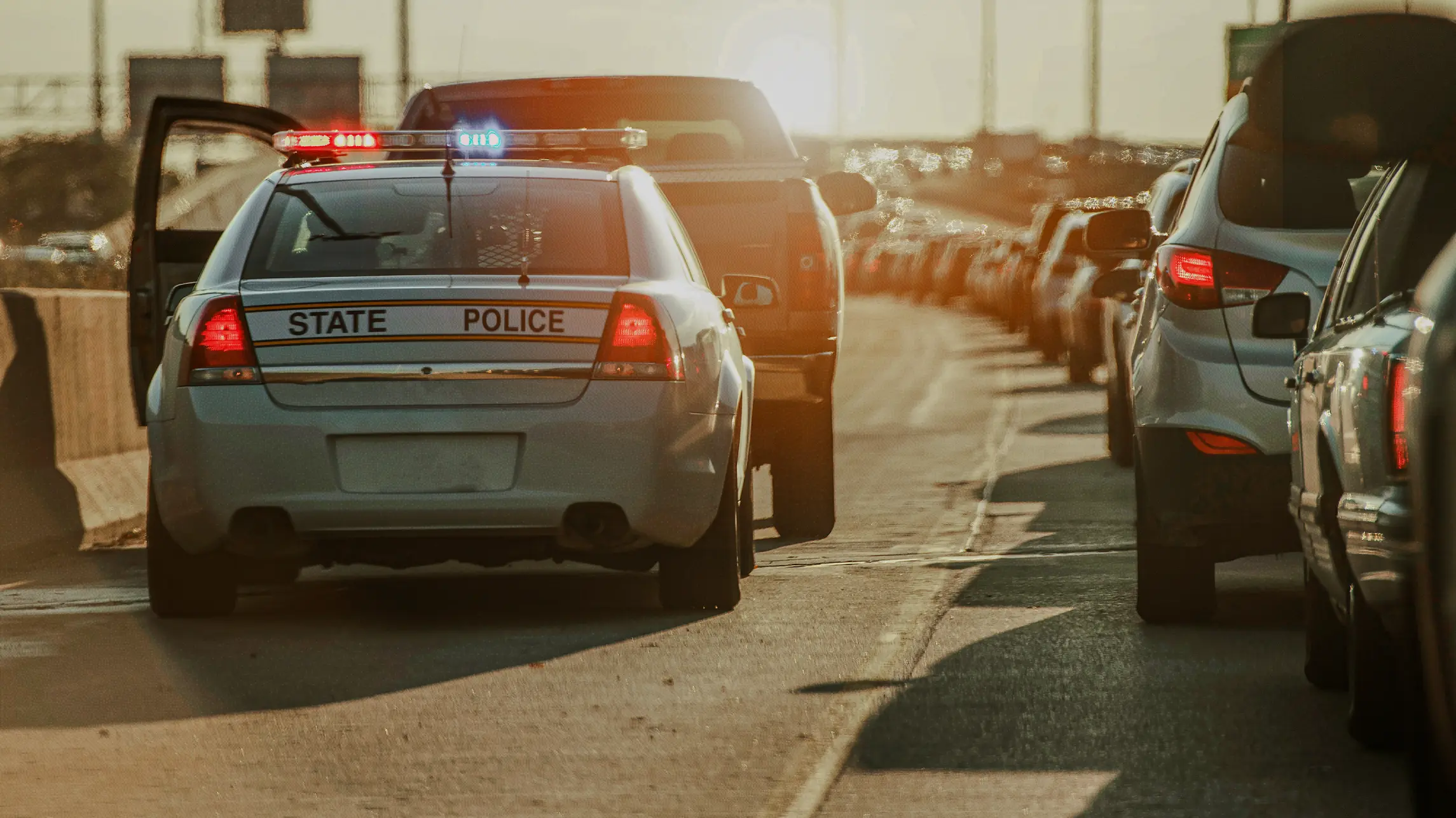 Police with stopped car on side of heavy traffic highway