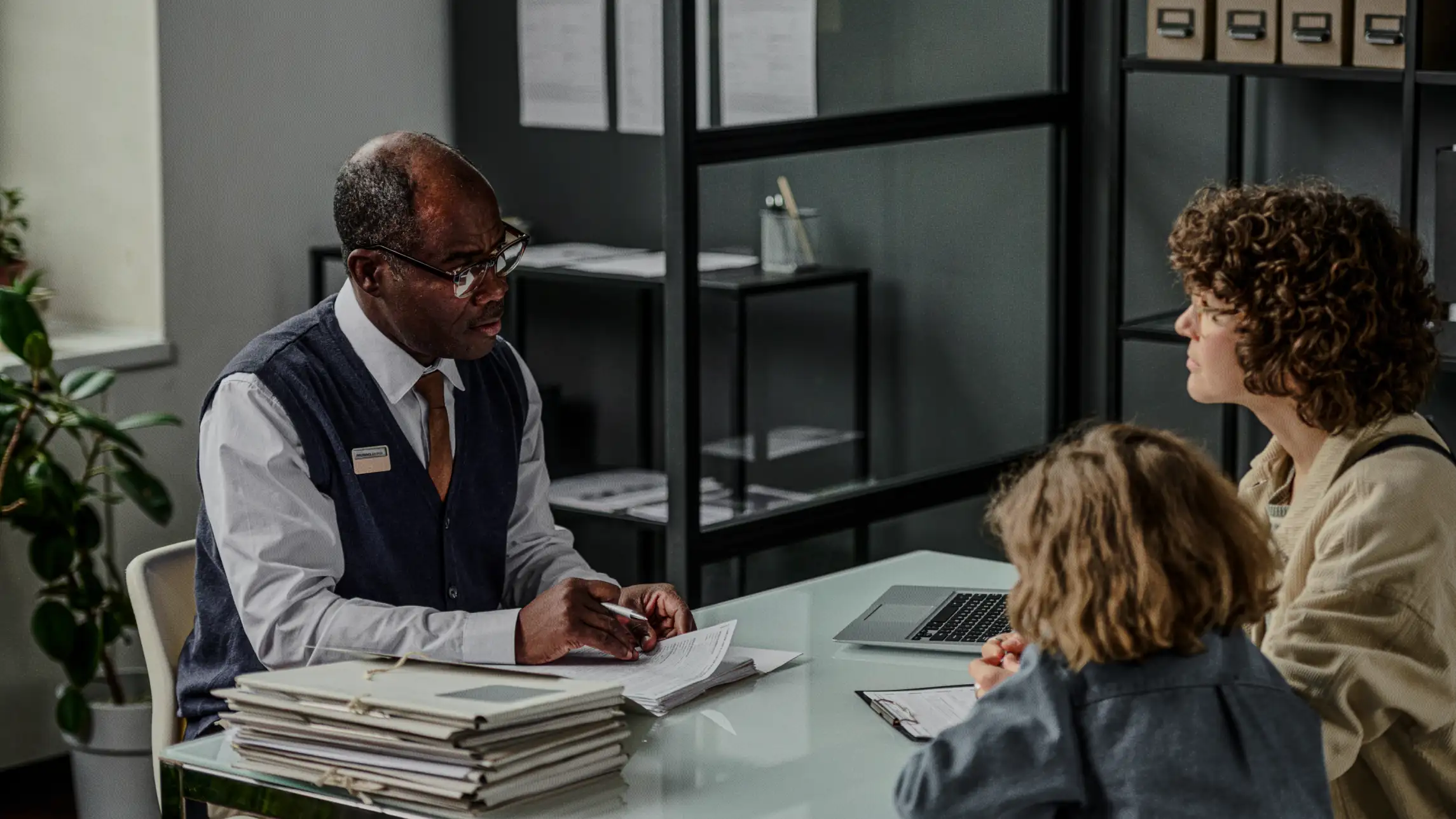 Man assisting woman and child with paperwork