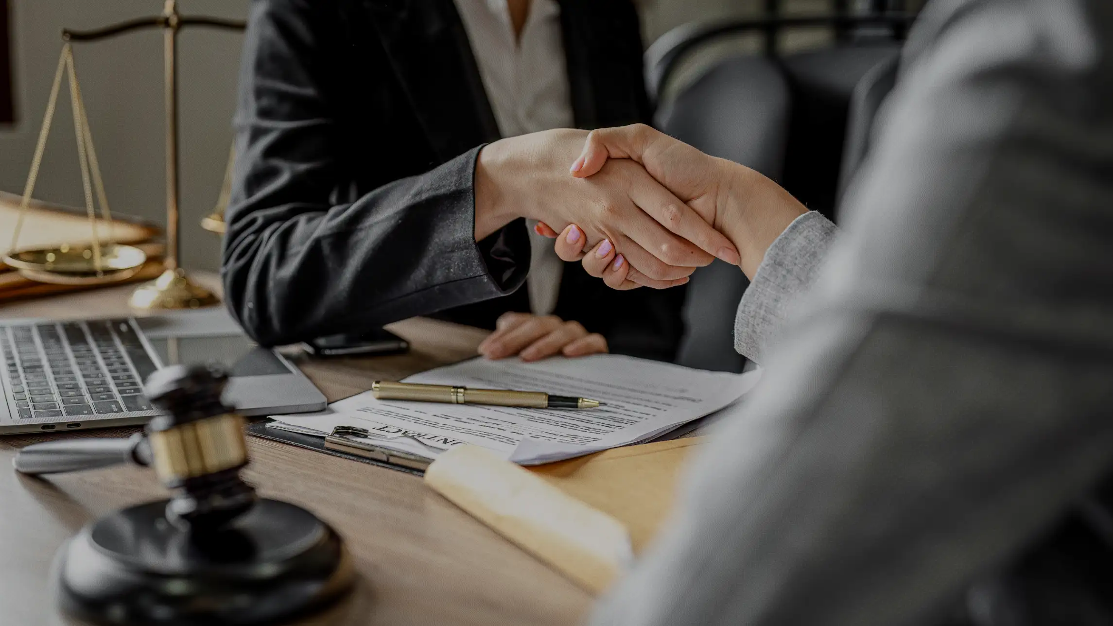 Man and woman have business handshake over paperwork
