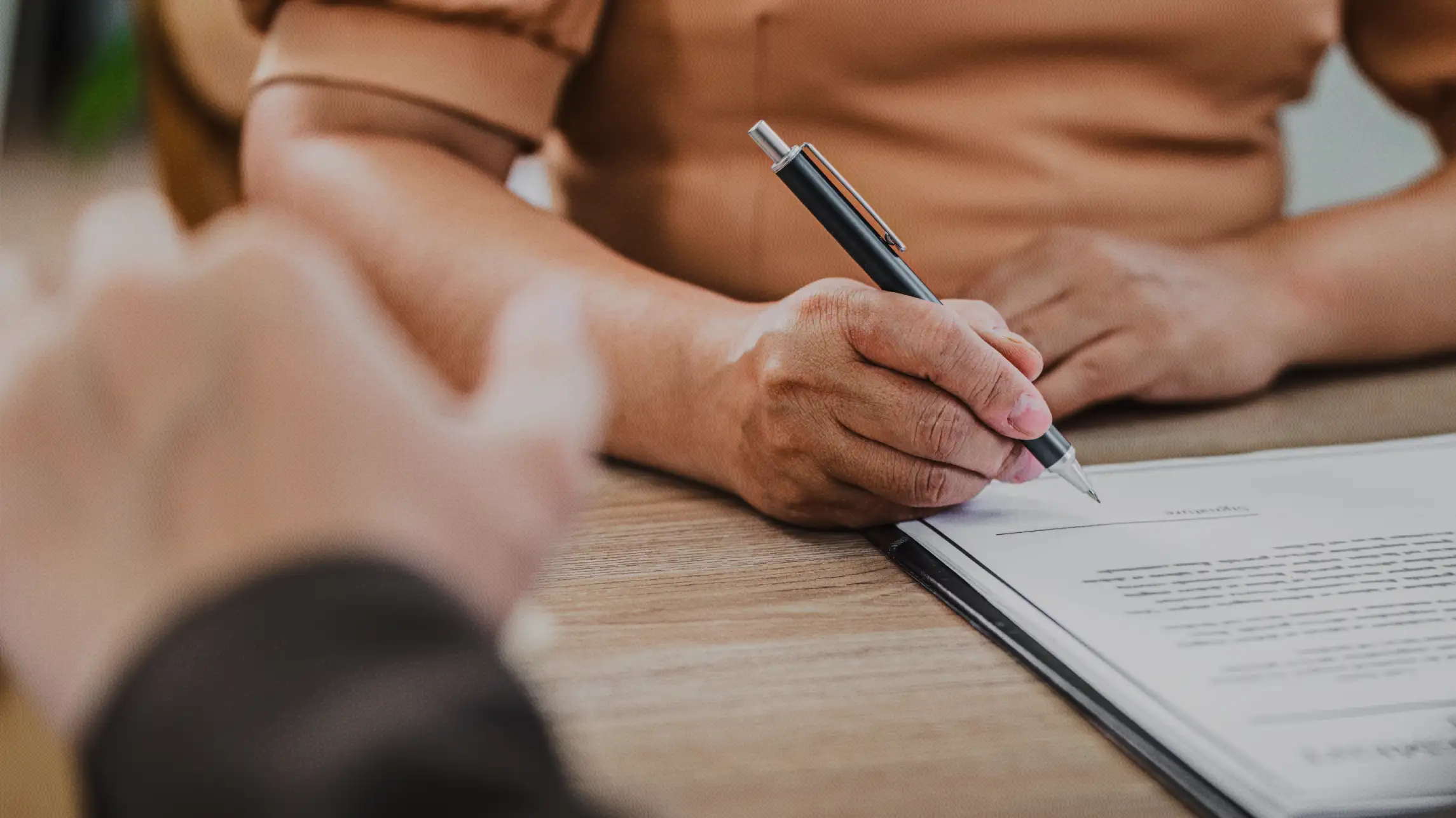 Woman signing paperwork with local bail bond agent
